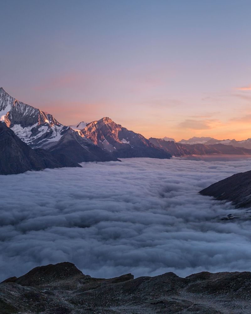 晨曦中徒步者背影面向雄伟雪山群峰的壮阔景观